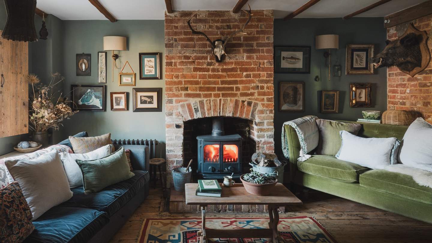 At its heart, a wood burning stove sits within an exposed brick fireplace