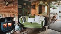 Both sofas are adorned with cushions and throws in a rich mix of natural textures and sheepskins from the family farm
