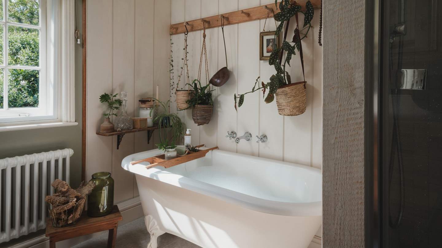 A large shower, freestanding slipper bath and a large oak reclaimed vanity, all sit in harmony with the mesmerising views beyond the window