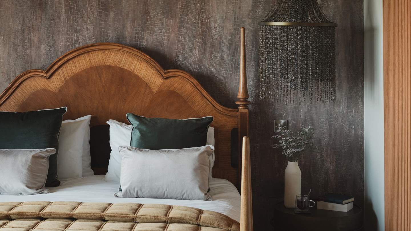 With a luxurious super king bed with the finest linens framed by a two-toned headboard