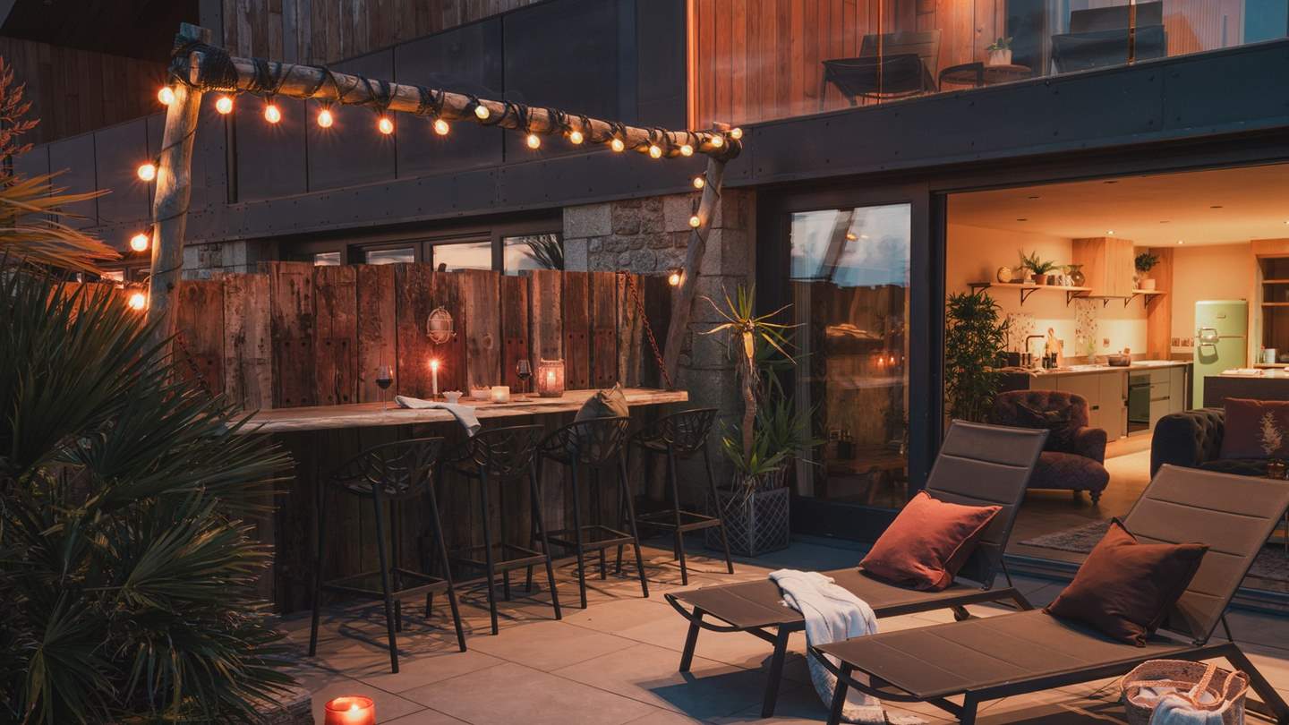 As night falls, the garden is illuminated by the warming glow of festoon lighting