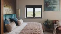 A feature wall of Venetian plaster rises behind the beds in both rooms
