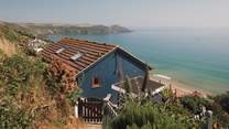 Uncover the sun-soaked deck overlooking the otherworldly oceanscapes of Whitsand Bay