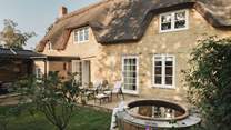 A  bordered lawn unfolds alongside a stone terrace, creating an idyllic setting for alfresco living