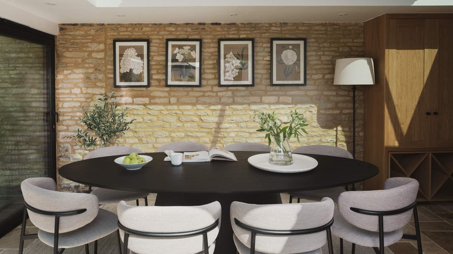Within the light-filled garden room lies a contemporary oval dining table