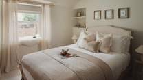 A neutral palette is accompanied by a Loaf double bed adorned with cosy linens and throws