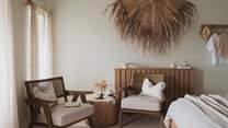 Lose time in the bedroom nook, where a side table and rattan lounge chairs provide the perfect backdrop for your morning coffee