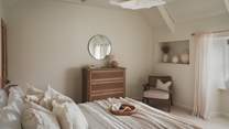 For storing belongings, you’ll find a chest of drawers by Feather and Black along with a hanging space
