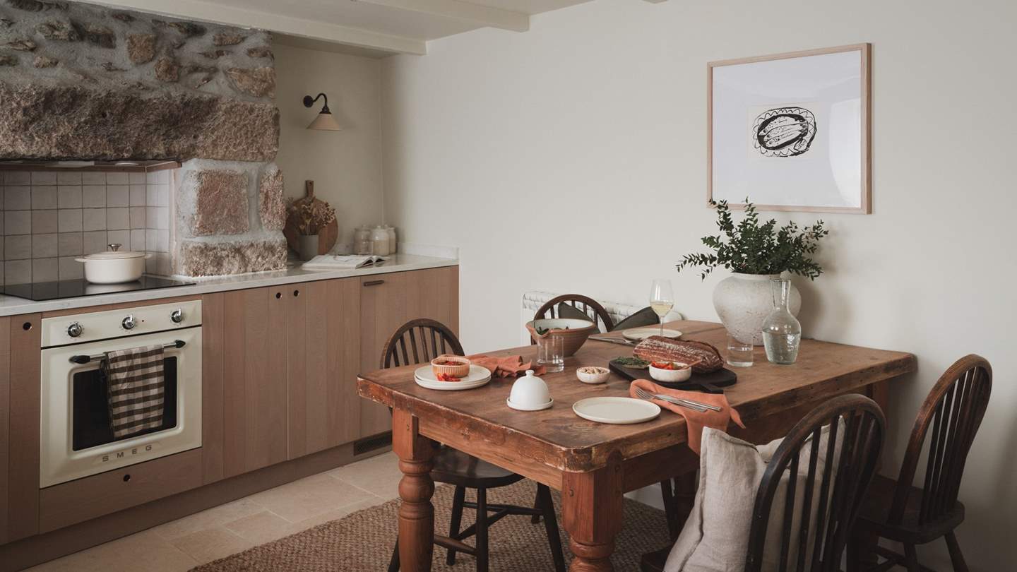 A farmhouse style dining table seats four, for those gathering together in the cottage kitchen of dreams