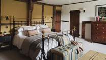Uncover the first bedroom, home to a super king brass bed enswathed in soft linens