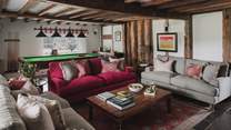 Offering sumptuous space to recline are three sofas and striped occasional chairs