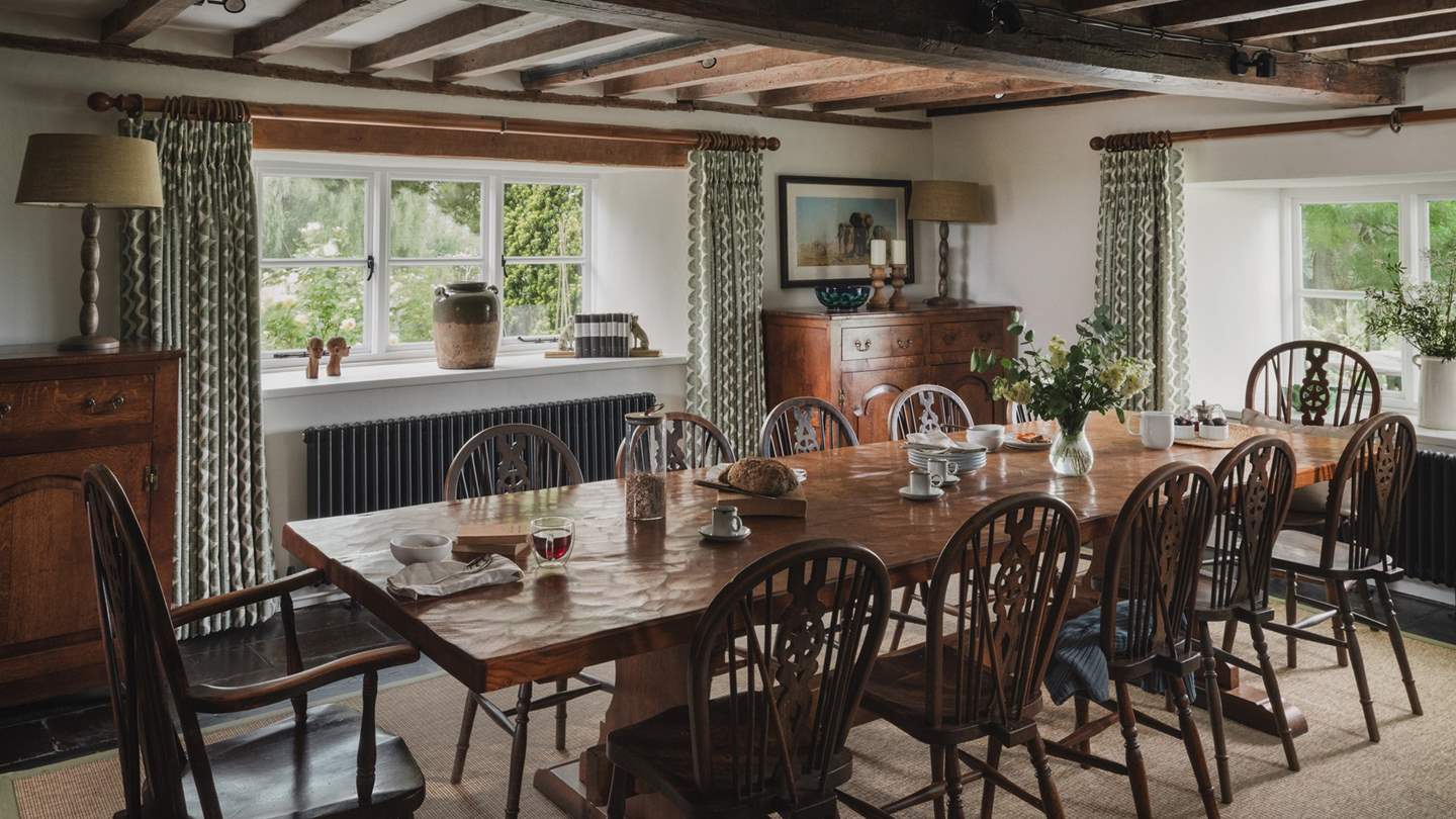 A table is complete with antique wheelback dining chairs for twelve guests
