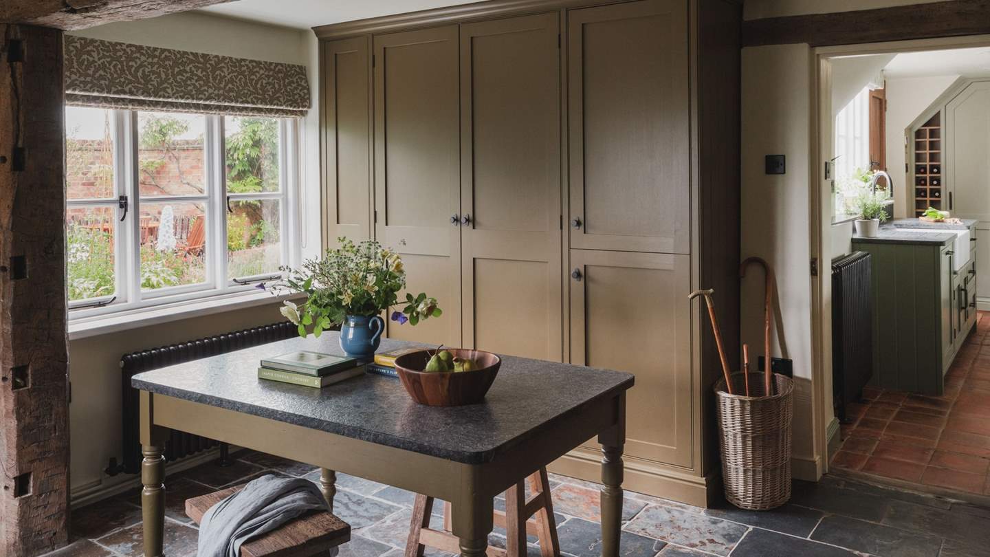 With pretty flagstone floors and sumptuous cabinetry, the entrance hall promises further country charm
