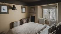 The charming window seat creates a cosy nook for curling up with a captivating read