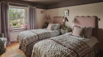 In a symphony of rich damson hues, the third bedroom welcomes restful nights