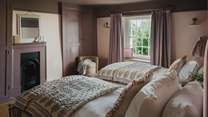 Luxurious reading lamps rest atop the bedside tables, creating an inviting space to unwind with a classic novel