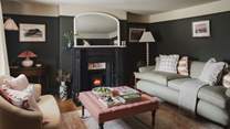 Two plush Rowen & Wren sofas positioned either side of a bijou wood burner