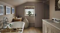 Take a short flight of steps to discover the soothing en suite bathroom