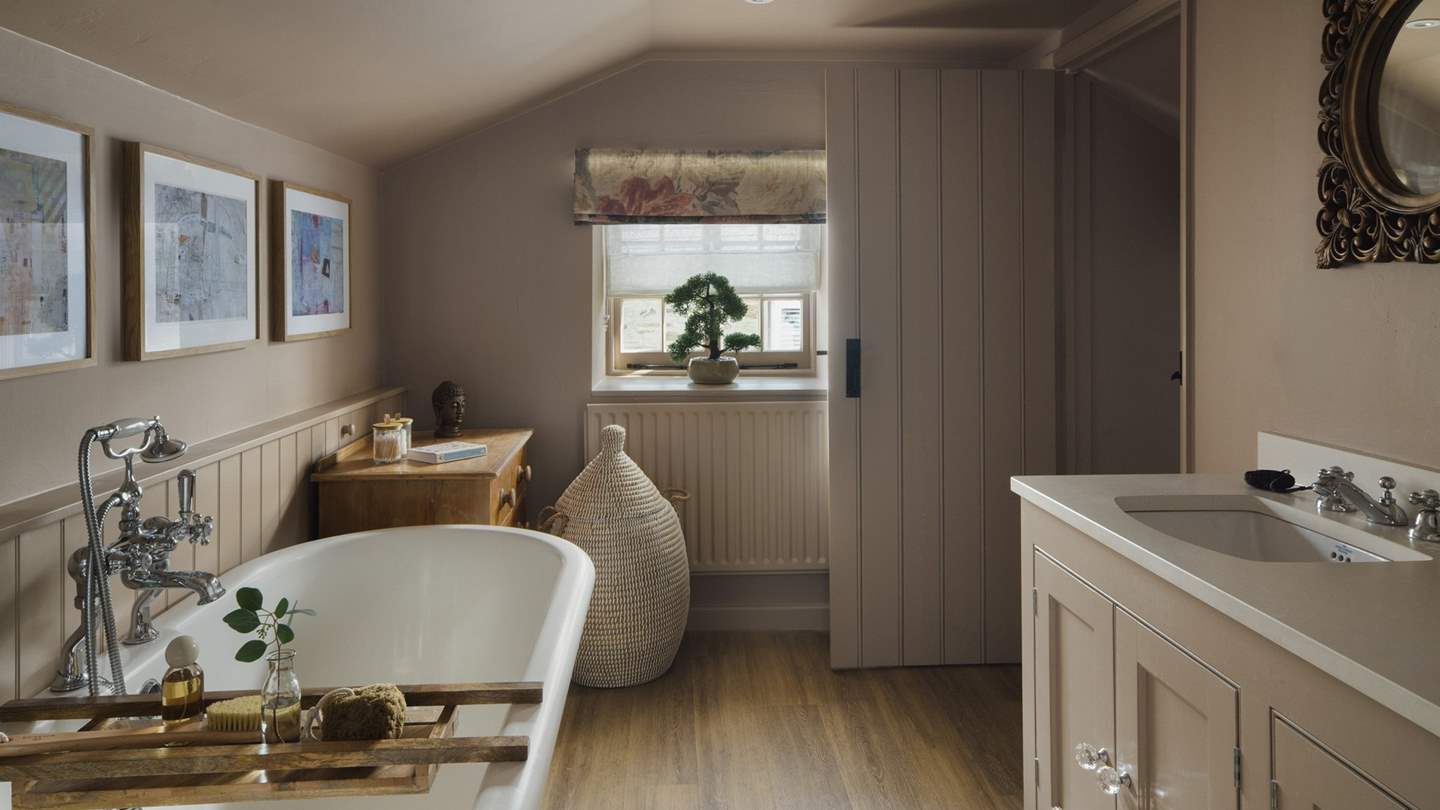 Take a short flight of steps to discover the soothing en suite bathroom