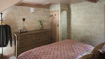 For storage, discover a chest of drawers and a small rail for hanging garments