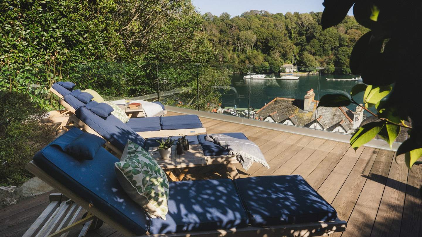 With a sleek glass balcony and an array of sun loungers, unwind beside uninterrupted river views