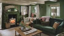 Drawing the eye in the main living room is a cream wood-burning stove, a welcome addition in the cooler months