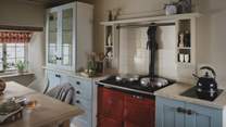 A cherry-red AGA beautifully contrasts pale blue cabinetry