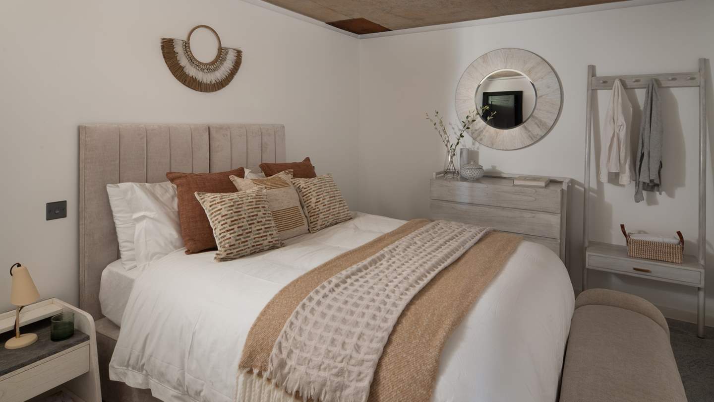 Tranquil hues adorn the walls, and an ottoman offers somewhere to rest for a spell