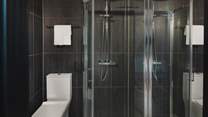 An ensuite bathroom with a bath and overhead shower offers comfort and convenience for self-care rituals throughout the day