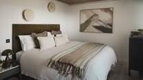 The first bedroom features a super king bed, beckoning for nights of restful repose