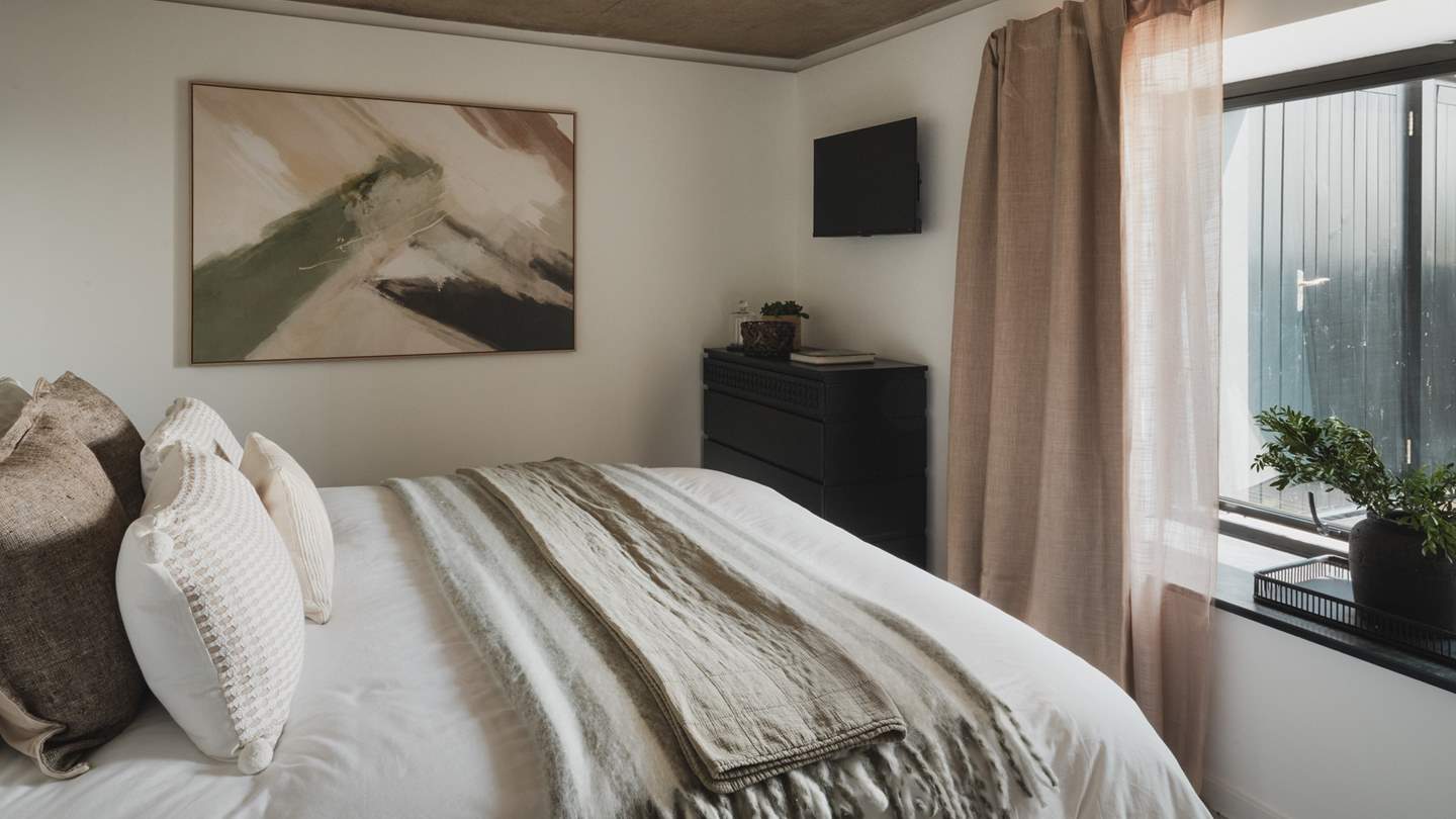 A chest of drawers and dedicated hanging rail provide space to stow belongings