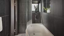 A bath and overhead shower offers comfort and convenience for self-care rituals throughout the day