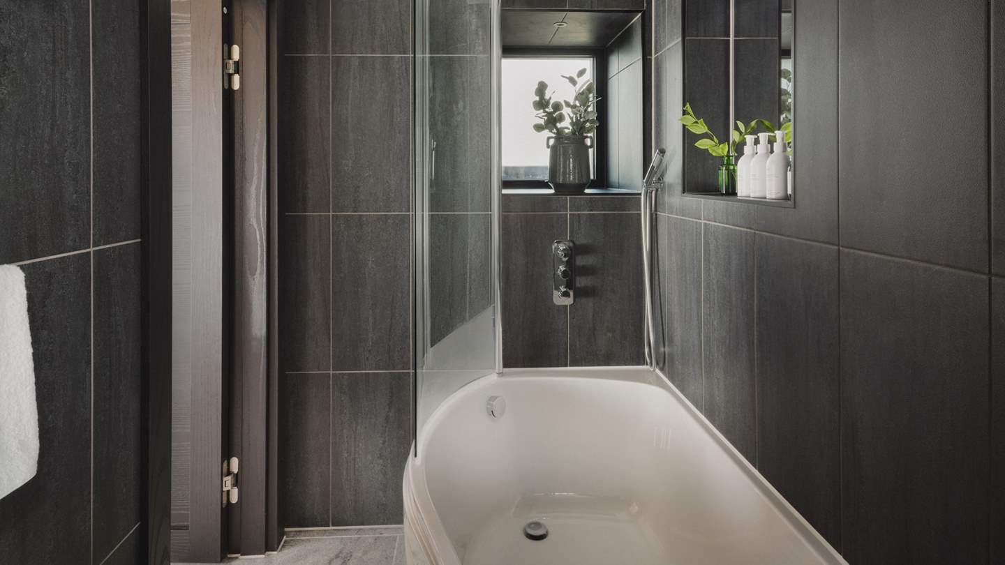 A bath and overhead shower offers comfort and convenience for self-care rituals throughout the day
