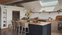 Generous oak worktops, dark textured cabinetry and a kitchen island offer a canvas for curated plates and popped corks. 