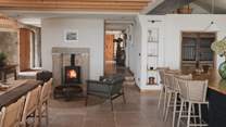 For atmospheric evenings, two more armchairs gather in front of a wood burning stove