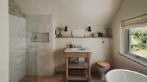 Uncover the family bathroom on the first floor, with a shower, bath, and heated towel rail