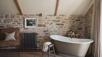 Encouraging moments of bubble-topped bliss, a freestanding rolltop bath overlooks reaching country vistas