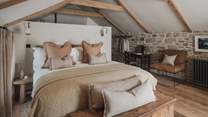 The master suite resides below a vaulted ceiling and enjoys mesmerising views from sliding balcony doors