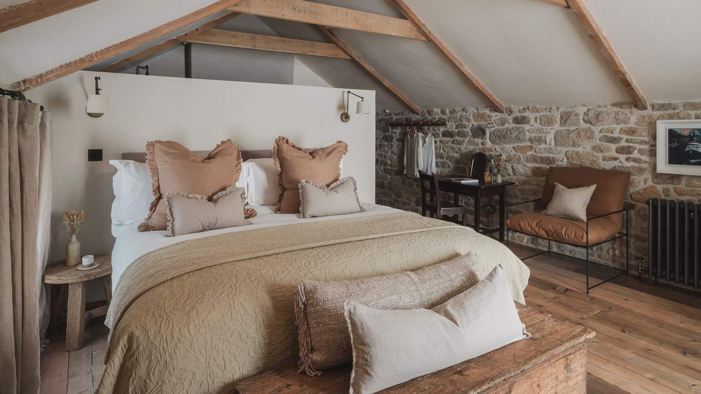 The master suite resides below a vaulted ceiling and enjoys mesmerising views from sliding balcony doors