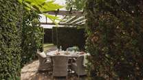 Gather for barbequed feasts on the alfresco dining table, residing beneath the dappled cover of the pergola