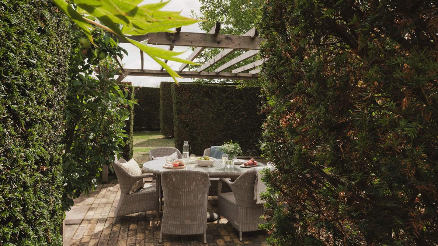 Gather for barbequed feasts on the alfresco dining table, residing beneath the dappled cover of the pergola