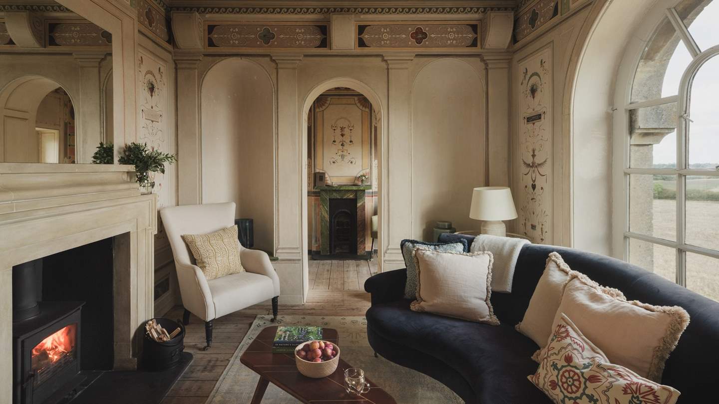 A wood burning stove invites for cosy evenings in the Renaissance-inspired living room 