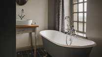 This sophisticated space is complete with a claw-foot bathtub with a handheld shower