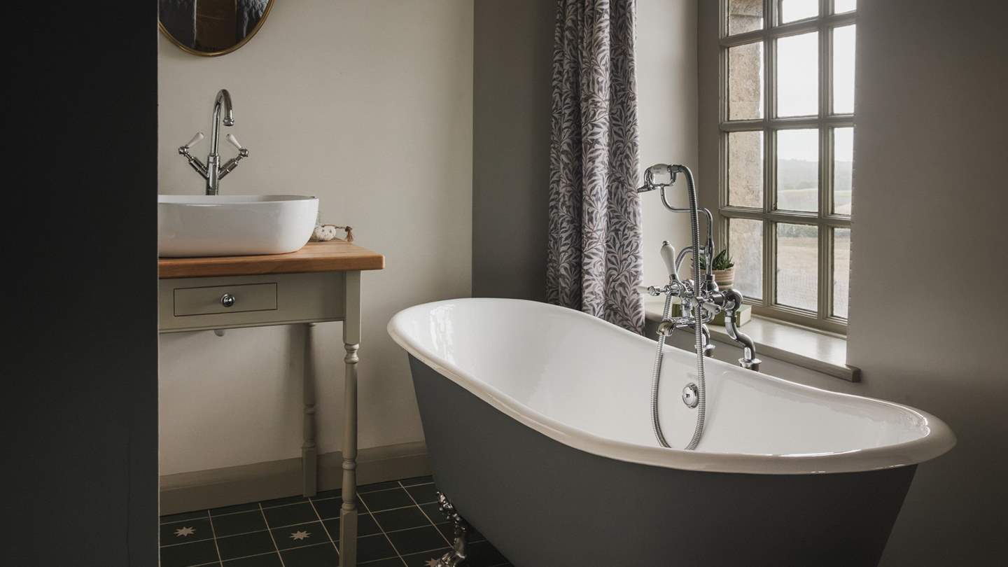 This sophisticated space is complete with a claw-foot bathtub with a handheld shower