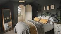 In the second bedroom, deeper tones invite soothing slumber within a plush king size bed