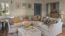 An additional living area continues the relaxing hues of home, with a plump corner sofa for endless comfort