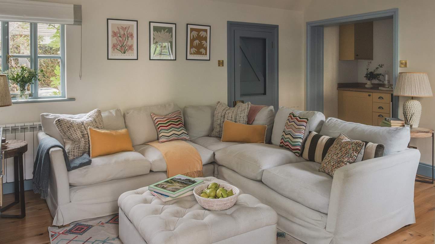 An additional living area continues the relaxing hues of home, with a plump corner sofa for endless comfort