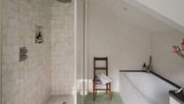 Cloudy Zelligge tiles by Bert and May adorn the spacious rainfall shower in the adjacent ensuite bathroom