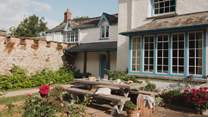 On the sweeping front lawn, a generous table for ten with rustic benches sets the scene for leisurely feasts 