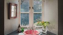 The bathroom is adorned in Lattice Cane wallpaper by Barneby Gates
